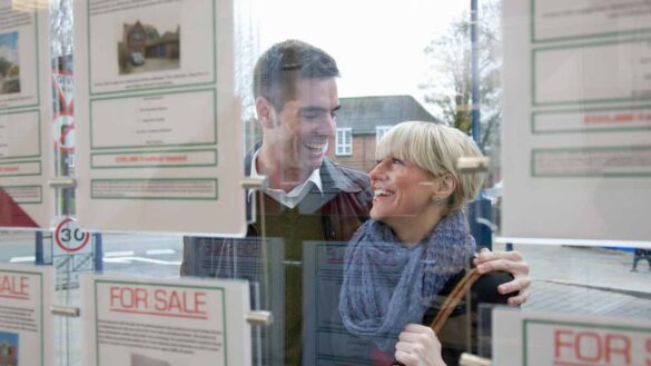 Desk move demotion, constructive dismissal: photo shows a happy couple looking into an estate agents' window.