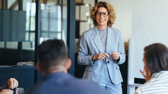 Woman talking to colleagues at work in office.